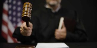 Judge with gavel and American flag in background.