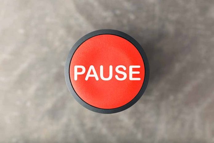 792571054 featured image Red button labeled "PAUSE" on gray background.