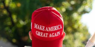 Red Make America Great Again hat on person's head.