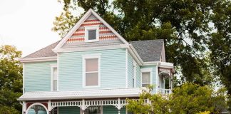 Light blue Victorian house with white trim and porch.