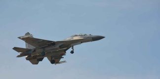 Fighter jet flying in a clear blue sky.