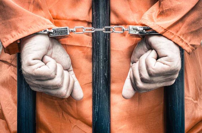 217094626 featured image Hands cuffed behind bars in prison uniform