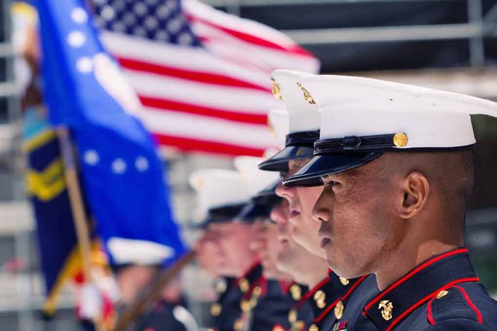 355868381 featured image Marines in uniform standing in line, American flags displayed.
