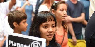 People at a protest holding signs against Planned Parenthood