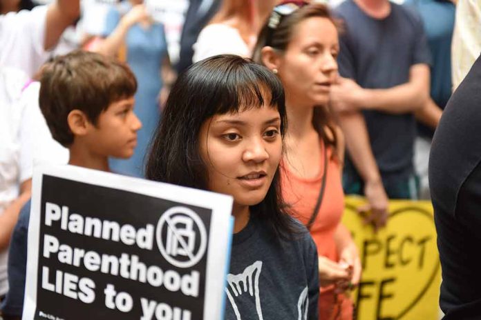 358817264 featured image People at a protest holding signs against Planned Parenthood