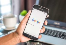 Hand holding smartphone with Google search page