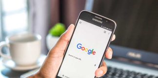 Hand holding smartphone with Google search page