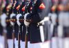 Military officers standing in formation holding rifles.