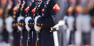 Military officers standing in formation holding rifles.