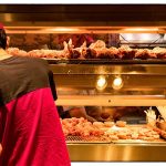 Person in red shirt at fried chicken counter