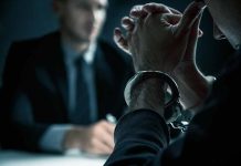 Person in handcuffs during interrogation with officer