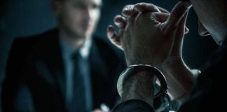 Person in handcuffs during interrogation with officer