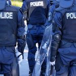 Police officers in riot gear with shields