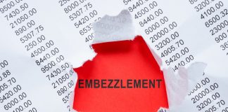 Torn paper revealing word embezzlement and numbers