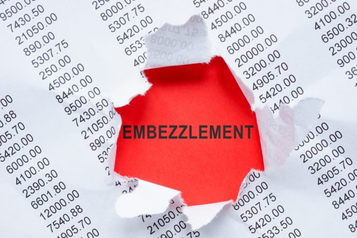 Torn paper revealing word embezzlement and numbers