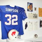 Blue jersey and helmet displayed with wall memorabilia