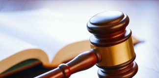 Gavel resting on sounding block beside open book