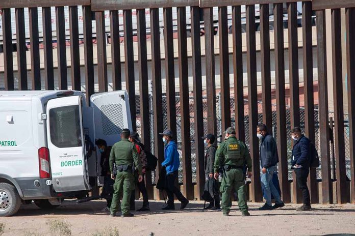 2079408475 featured image People near border fence with border patrol van