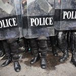 Police officers in riot gear holding shields