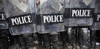 Police officers in riot gear holding shields