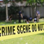 Yellow crime scene tape blocking grassy area