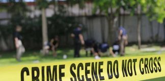 Yellow crime scene tape blocking grassy area