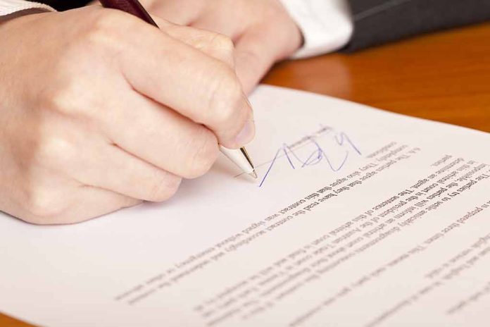 66092728 featured image Hand signing a document with a pen.