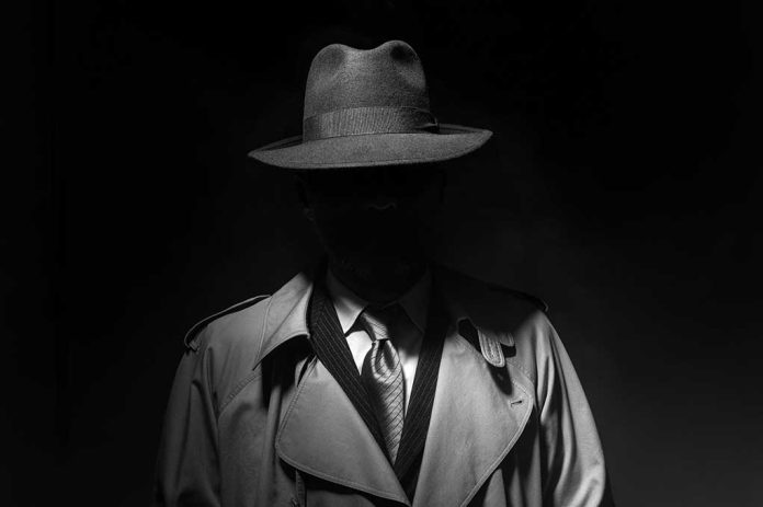 699567733 featured image Person in trench coat and fedora face obscured by shadow