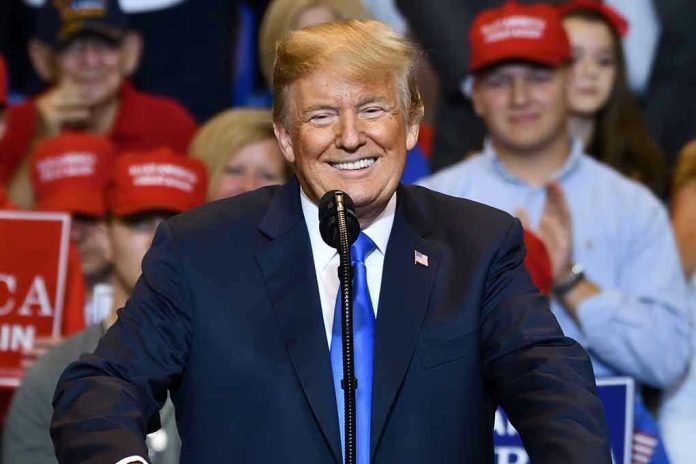 Man in suit speaking at rally with red hats