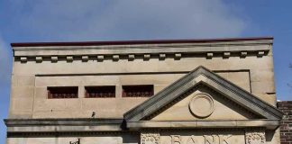 Stone building facade with bank sign and columns
