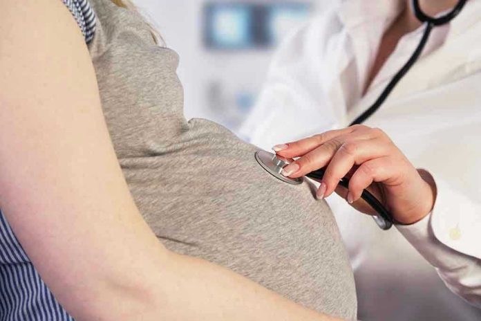 Doctor uses stethoscope on pregnant woman's belly