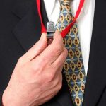 Person holding a whistle on a red lanyard