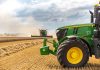 A green tractor in a wheat field