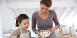 A mother and daughter baking together in a bright kitchen