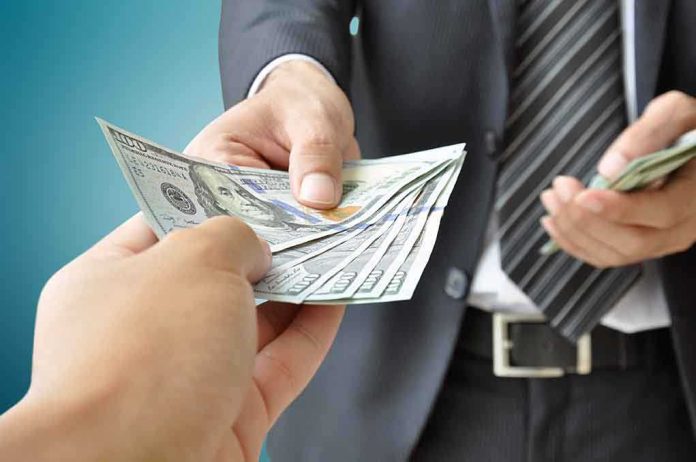 shutterstock_209123032.jpg Two hands exchanging cash in a business setting