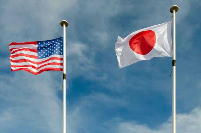 USA and Japan flags flying on flagpoles.