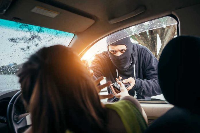 Masked person robbing a woman inside a car.