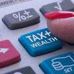 Finger pressing calculator tax and wealth button