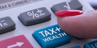 Finger pressing calculator tax and wealth button