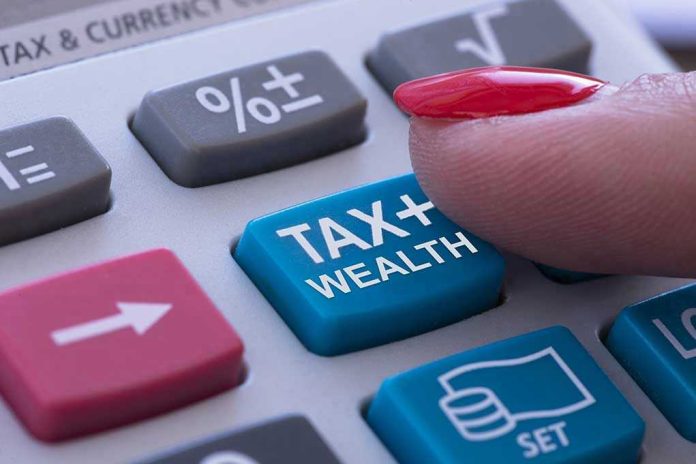 Finger pressing calculator tax and wealth button