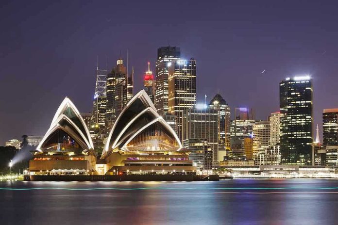 Sydney Opera House at night with city skyline.