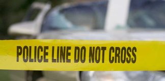 Yellow police tape in front of a car