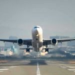 Airplane taking off from runway in urban area