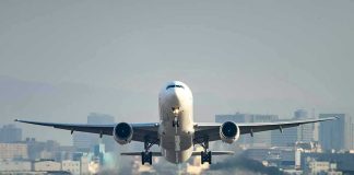 Airplane taking off from runway in urban area