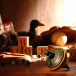 A wooden spinning top surrounded by vintage toys and colorful blocks