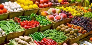 A vibrant display of assorted fruits and vegetables in baskets at a market