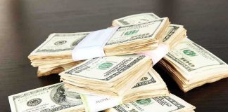 Stacks of bundled cash on a wooden table