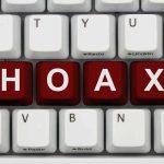 Close-up of a computer keyboard with the word 'HOAX' spelled out in red keys