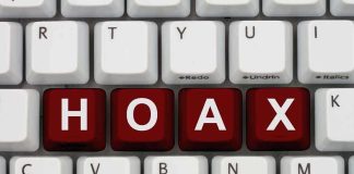 Close-up of a computer keyboard with the word 'HOAX' spelled out in red keys