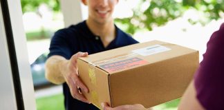 A delivery person handing a package to a customer at their doorstep